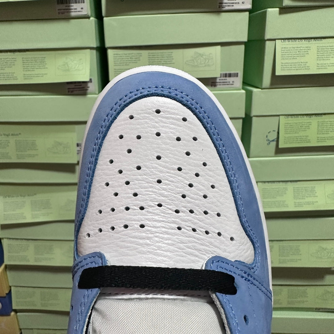 Light blue and white shoe toe box with perforations and lace strap.