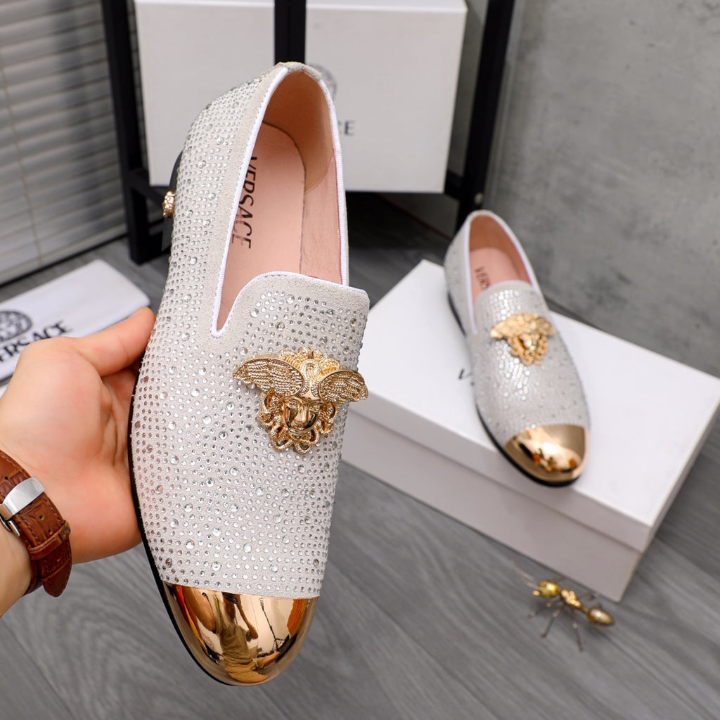 Luxury Versace loafers with white sparkle finish, gold crest ornament, and slip-on cut