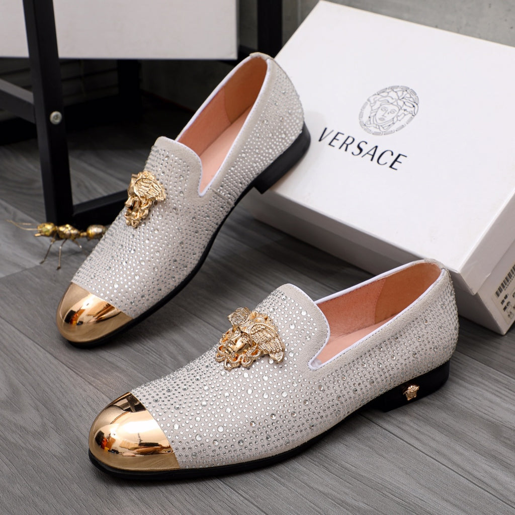 Luxury Versace loafers in white rhinestones with gold crest detail and rounded metallic toe