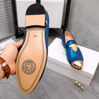 Loafer outsole with tan insole and logo, showing blue rhinestone upper underside