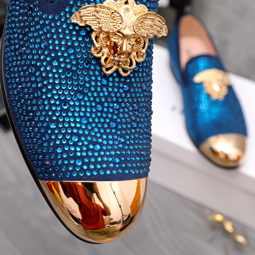 Blue rhinestone loafer detail with gold lion emblem and metallic toe trim