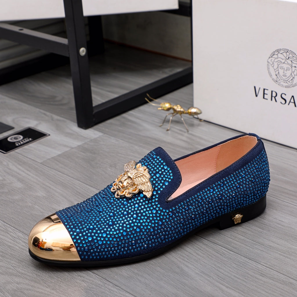 Blue rhinestone slip-on loafers with gold lion emblem and metallic toe cap