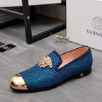 Blue rhinestone slip-on loafers with gold lion emblem and metallic toe cap