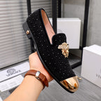 Black glitter loafers with gold-toned crest detail and shiny gold-toned toe panels