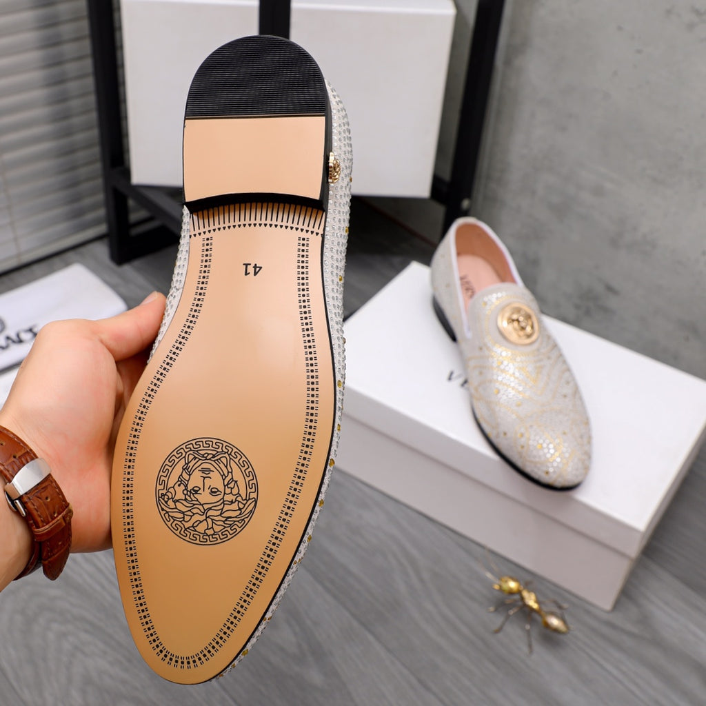 Outsole view of white slip-on loafer with tan rubber sole and circular logo stamp