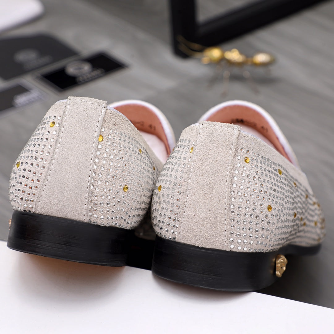Back view of white studded slip-on loafers showing black heel and side panel trim