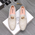 Embellished white slip-on loafer with gold-tone stud pattern and round medallion accent