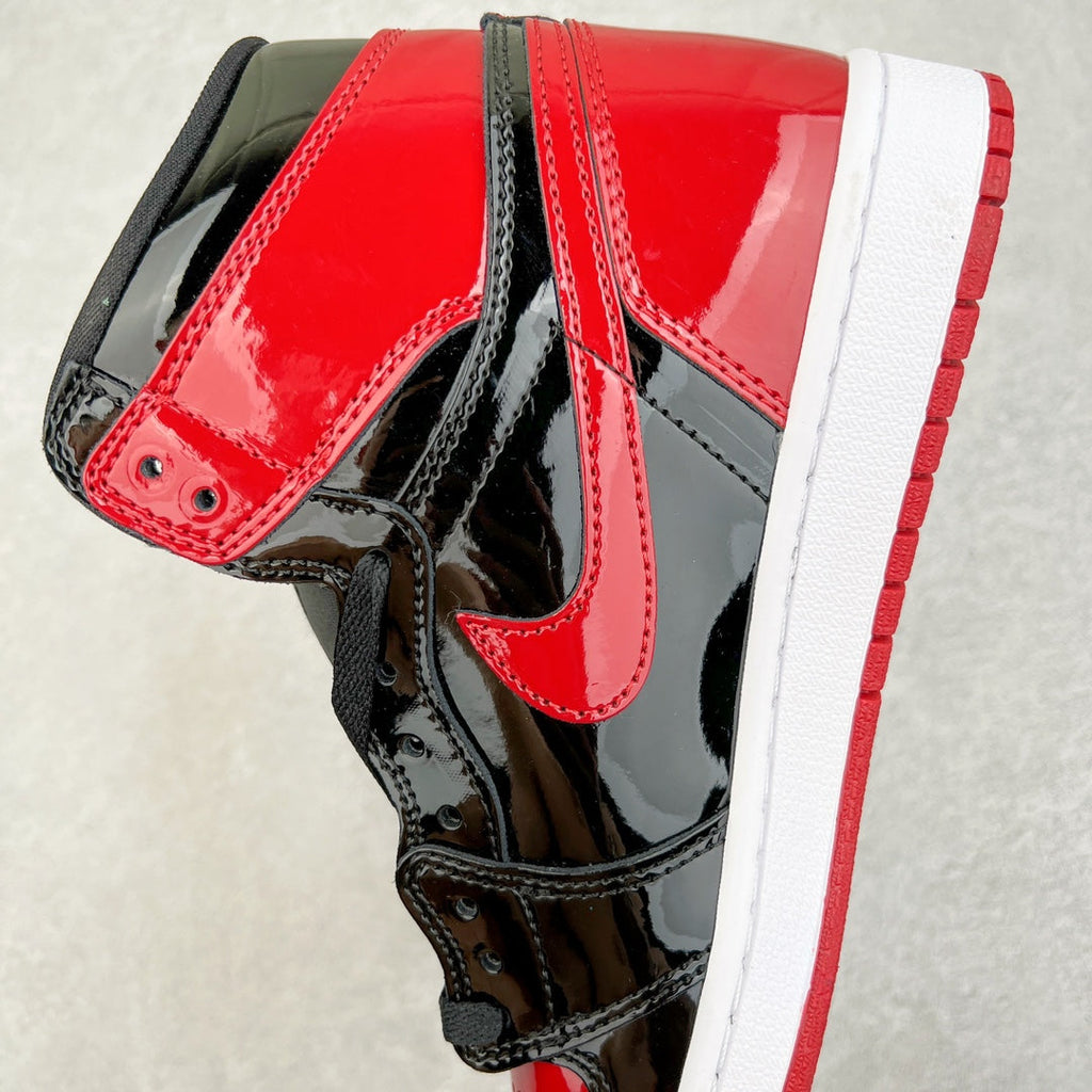 High-top patent sneaker upper in red with black panels, Nike swoosh, and white midsole.