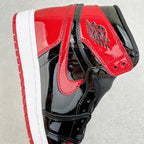 High-top sneaker with red collar panel, black overlays, and wing logo on ankle.