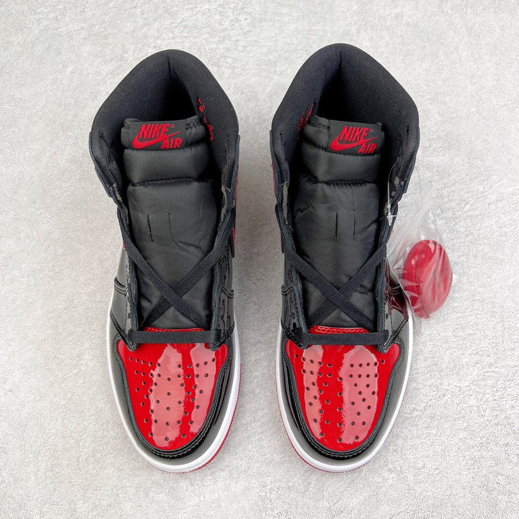 Pair of black high-top sneakers with red perforated toe box and Nike Air on tongue.