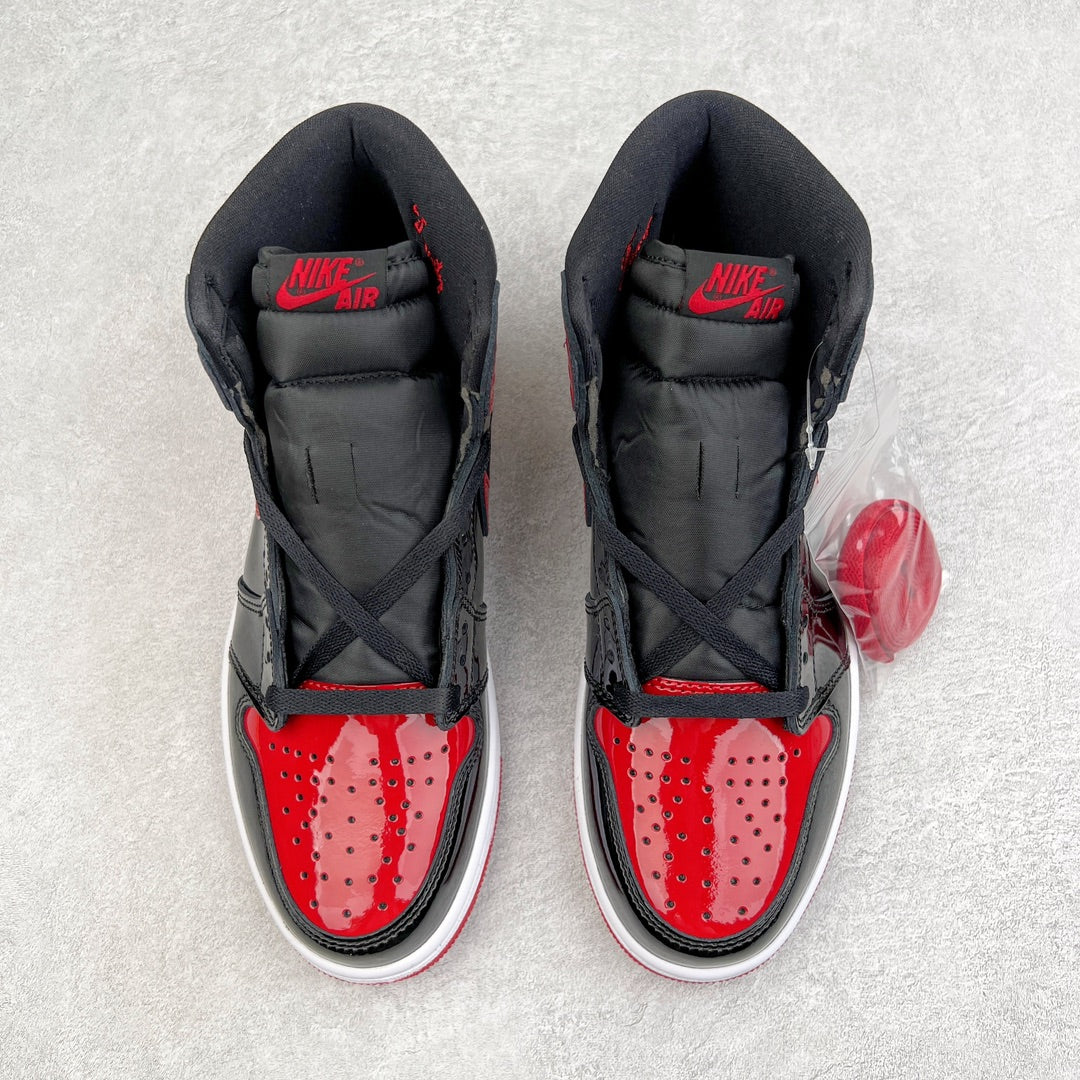 Pair of black high-top sneakers with red perforated toe box and Nike Air on tongue.