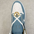 Denim blue and white high-top sneaker toe close-up with perforations, gold lace charm