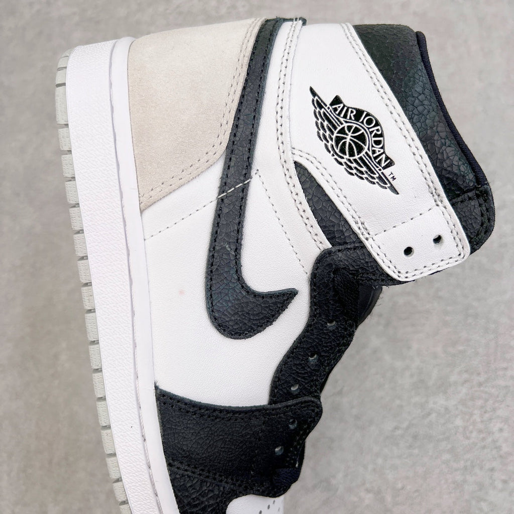 High-top sneakers with white leather upper, black Swoosh, and Wings logo on the collar