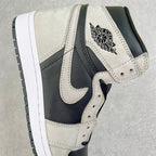 High-top sneakers with cream upper, navy swoosh, and Air Jordan wing logo on ankle.
