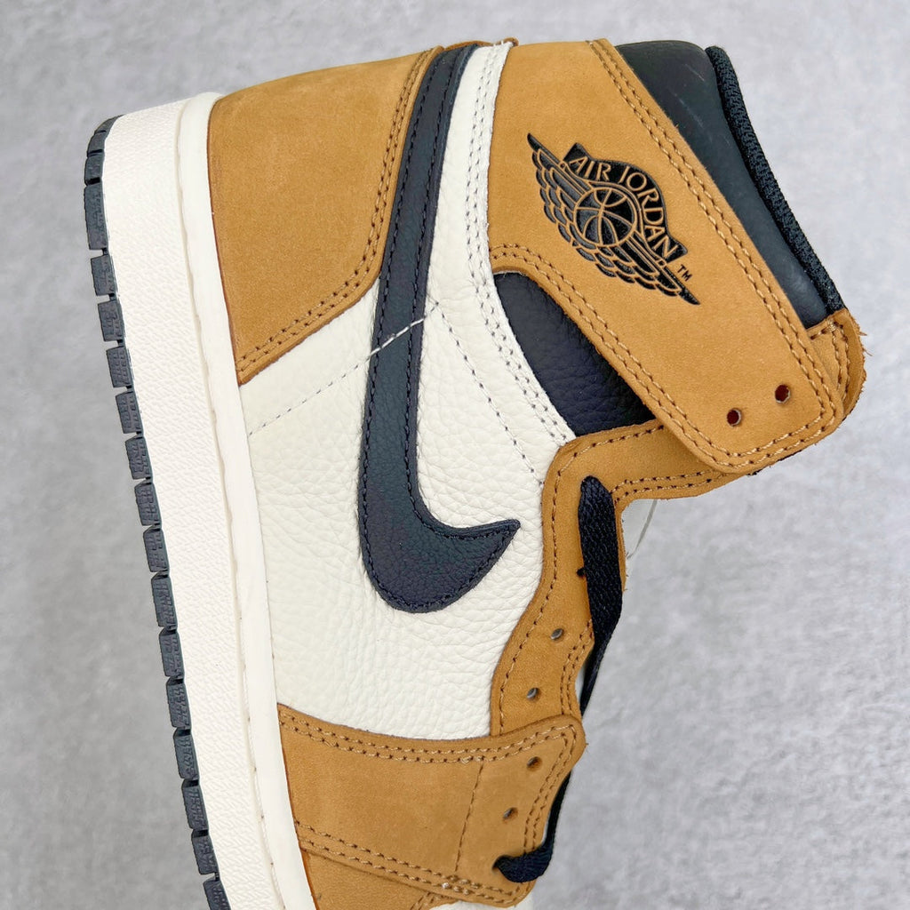 High-top sneaker side view with Air Jordan wing logo, tan suede, navy swoosh, white paneling.