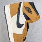 High-top sneaker side view with Air Jordan wing logo, tan suede, navy swoosh, white paneling.