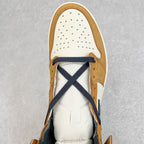 High-top sneaker toe with tan suede, white perforated panels, and navy crisscross laces.