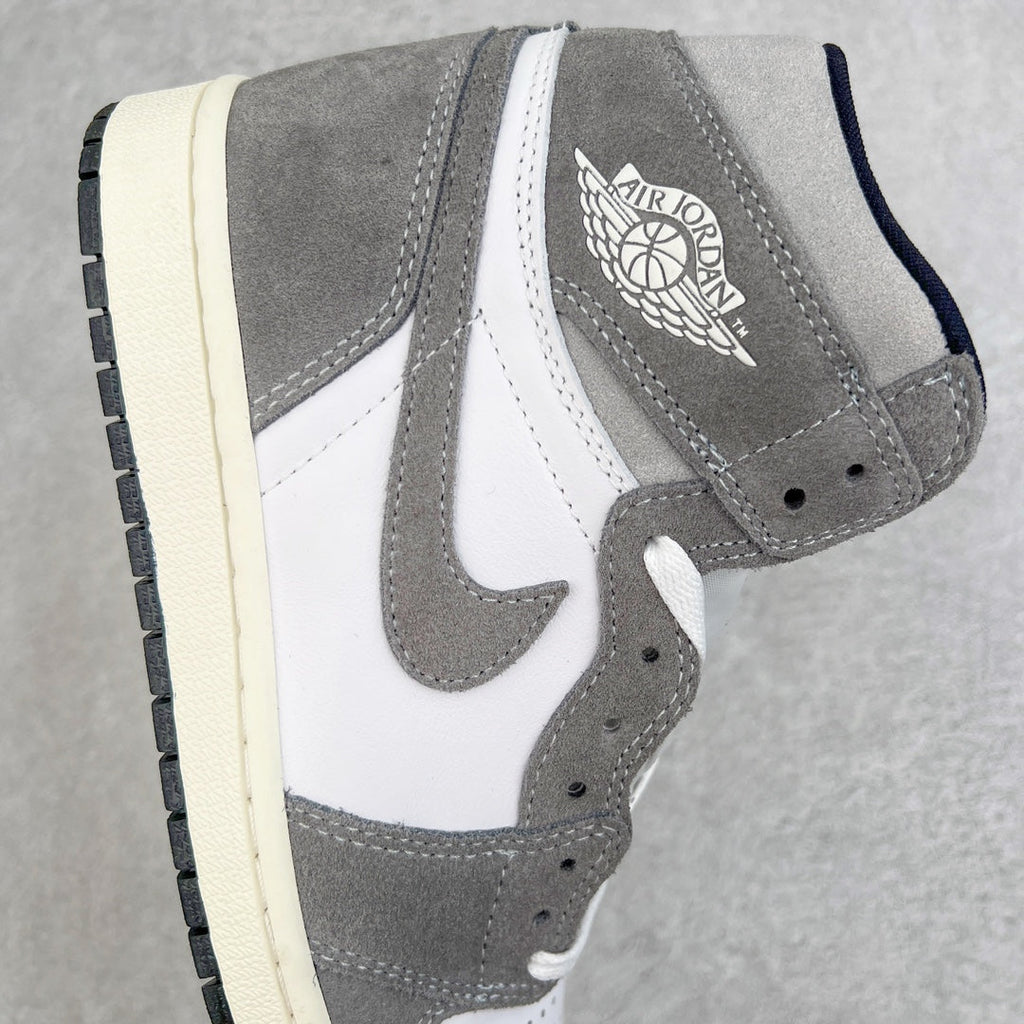 High-top sneaker side view with gray suede, white paneling, and Jordan logo near ankle.