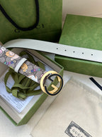 Gucci belt in packaging with cartoon print strap and gold-toned round logo buckle