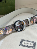 Gucci belt showing round buckle detail and multicolor cartoon pattern on light gray leather