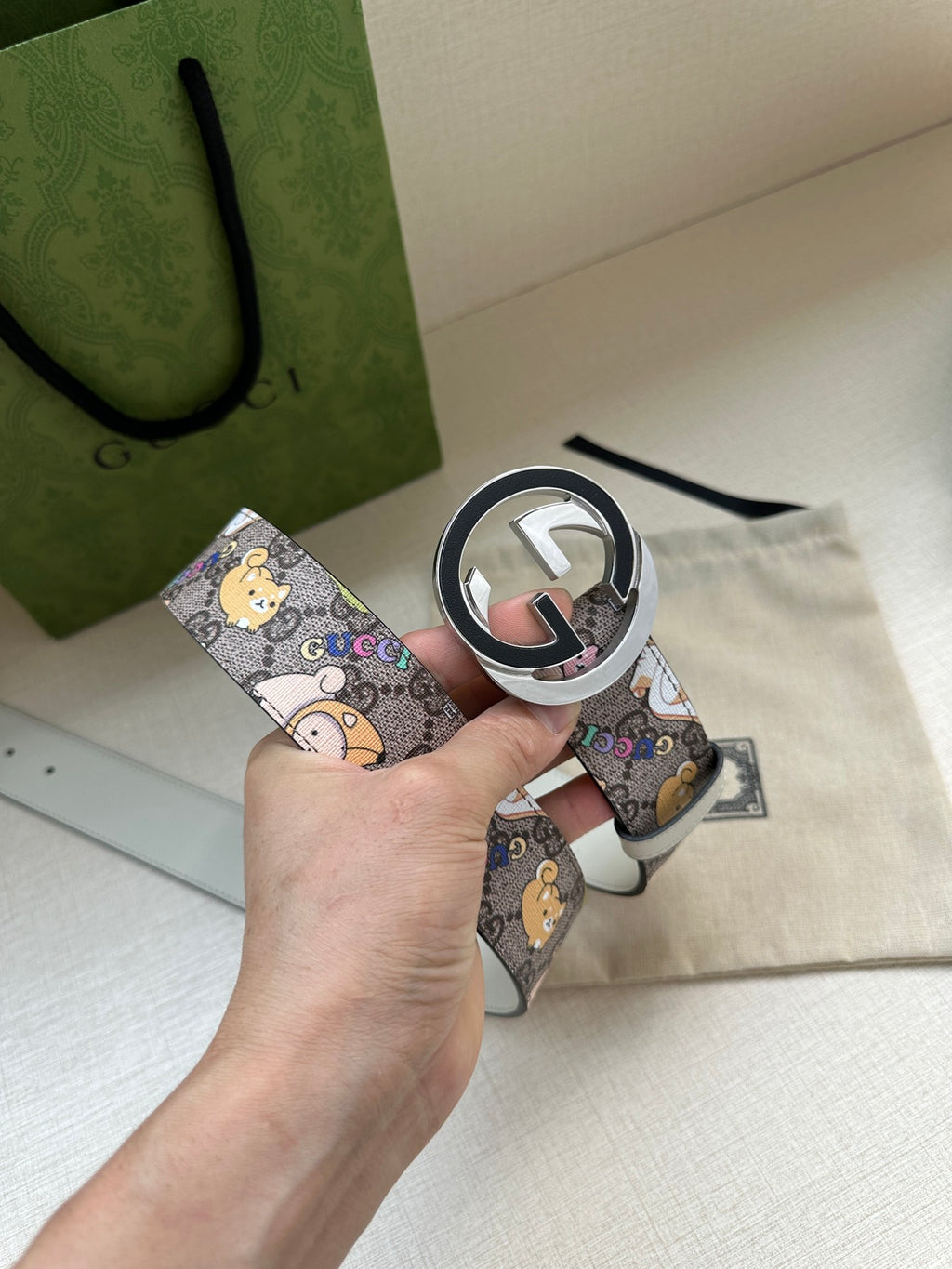 Gucci belt with multicolor cartoon pattern and round logo buckle on light gray leather