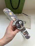 Gucci belt with multicolor cartoon print and round logo buckle on a light gray strap