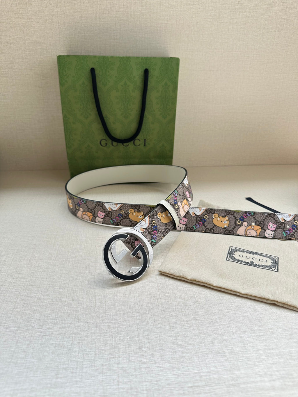 Gucci belt with multicolor cartoon print, round logo buckle, and light gray strap