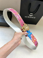 Versace belt with pink and blue floral strap and gold lion buckle on white