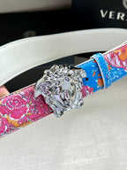 Versace belt close-up: multicolor floral strap and silver lion buckle on white