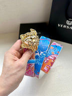 Versace belt with blue and pink floral strap and gold lion buckle