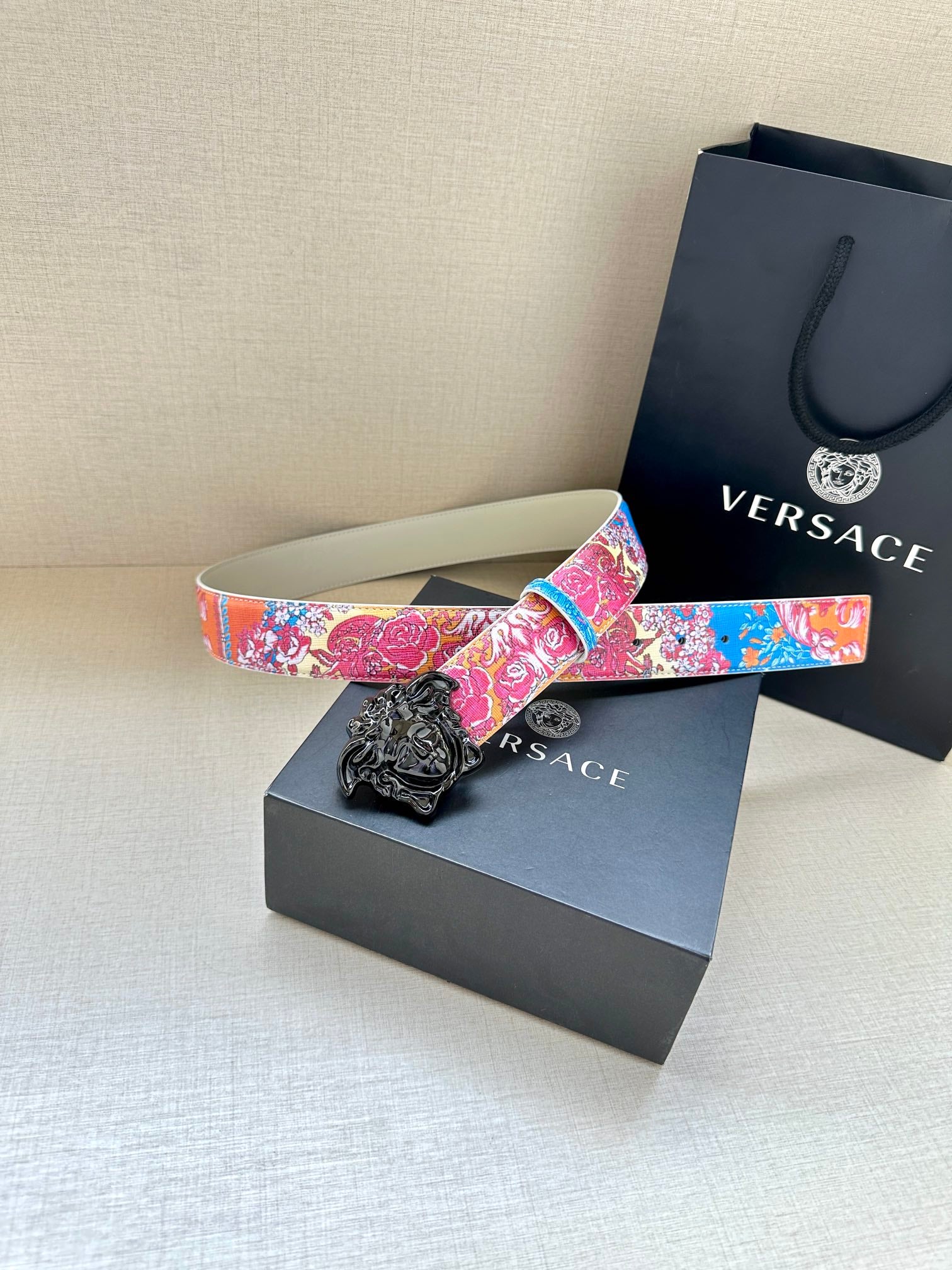 Versace belt with multicolor floral print and black lion buckle on white