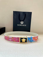 Versace belt with multicolor patterned strap, gold Medusa buckle, laid on light background