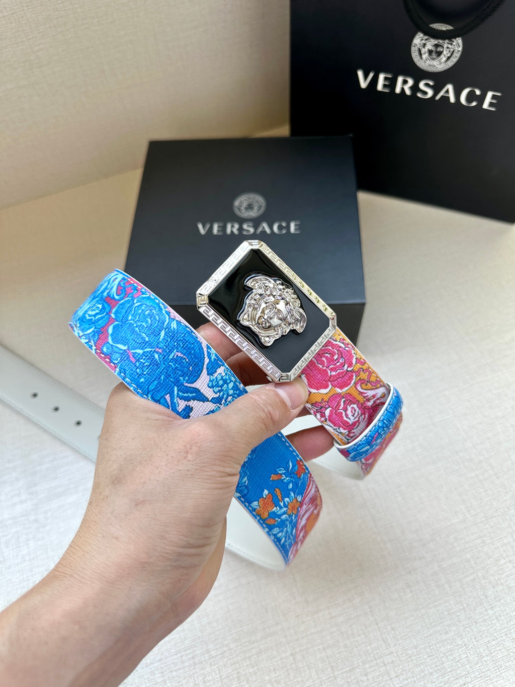 Versace belt with blue and pink patterned strap, gold Medusa buckle in dark frame