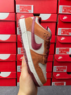 Nike Dunk Low sneaker showing heel and side view; tan suede, burgundy swoosh, cream sole
