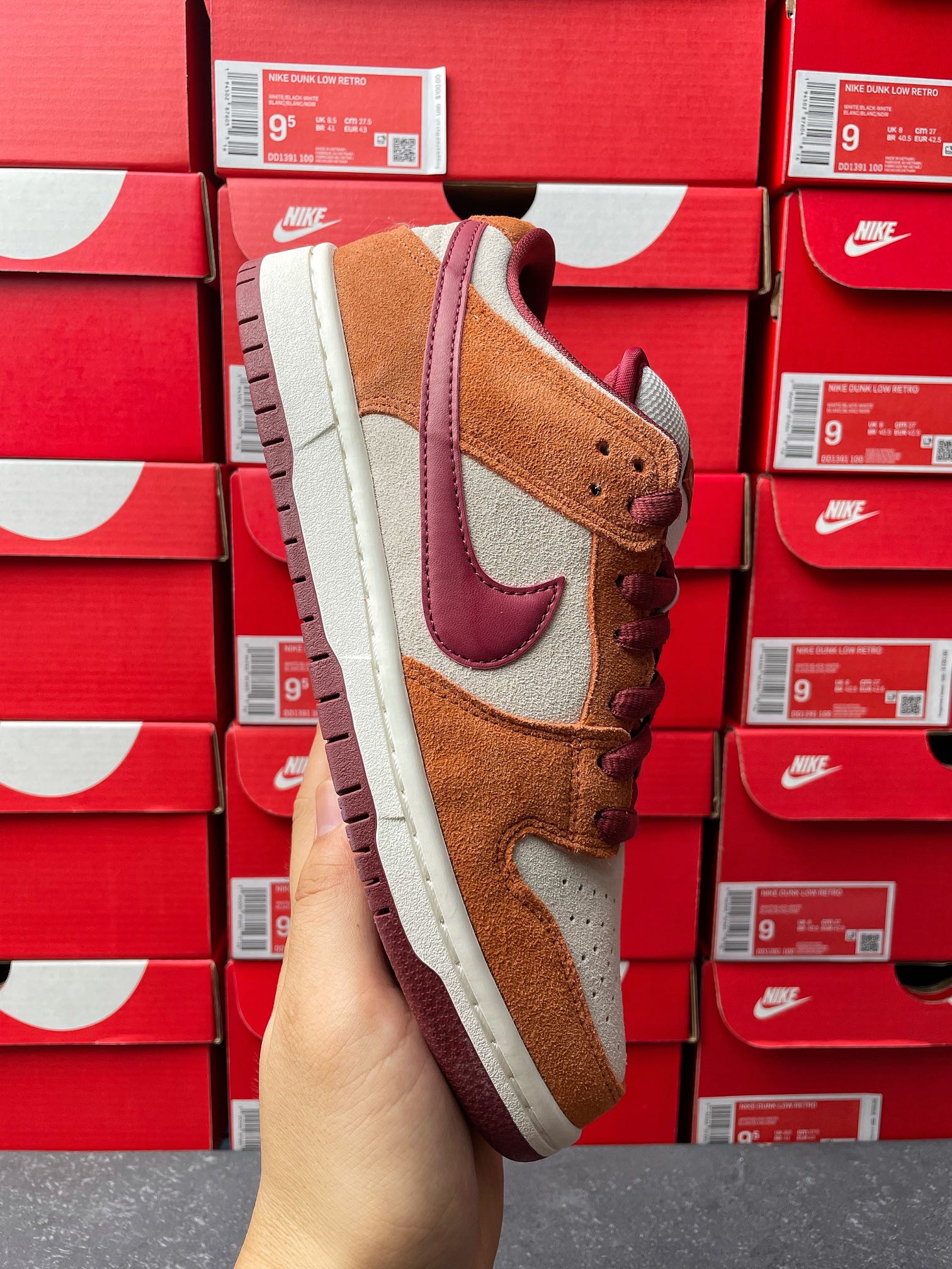 Nike Dunk Low sneaker showing heel and side view; tan suede, burgundy swoosh, cream sole