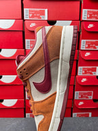 Nike Dunk Low sneaker quarter view with tan suede, cream panels, burgundy laces, white midsole