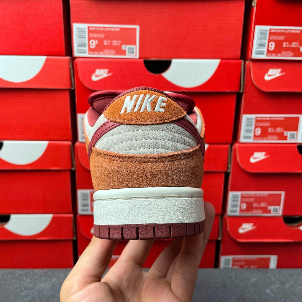 Nike Dunk Low sneaker back view with Nike SB label, tan suede, gray panel, cream midsole