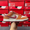 Nike Dunk Low sneaker with tan suede panels, burgundy swoosh, and cream sole