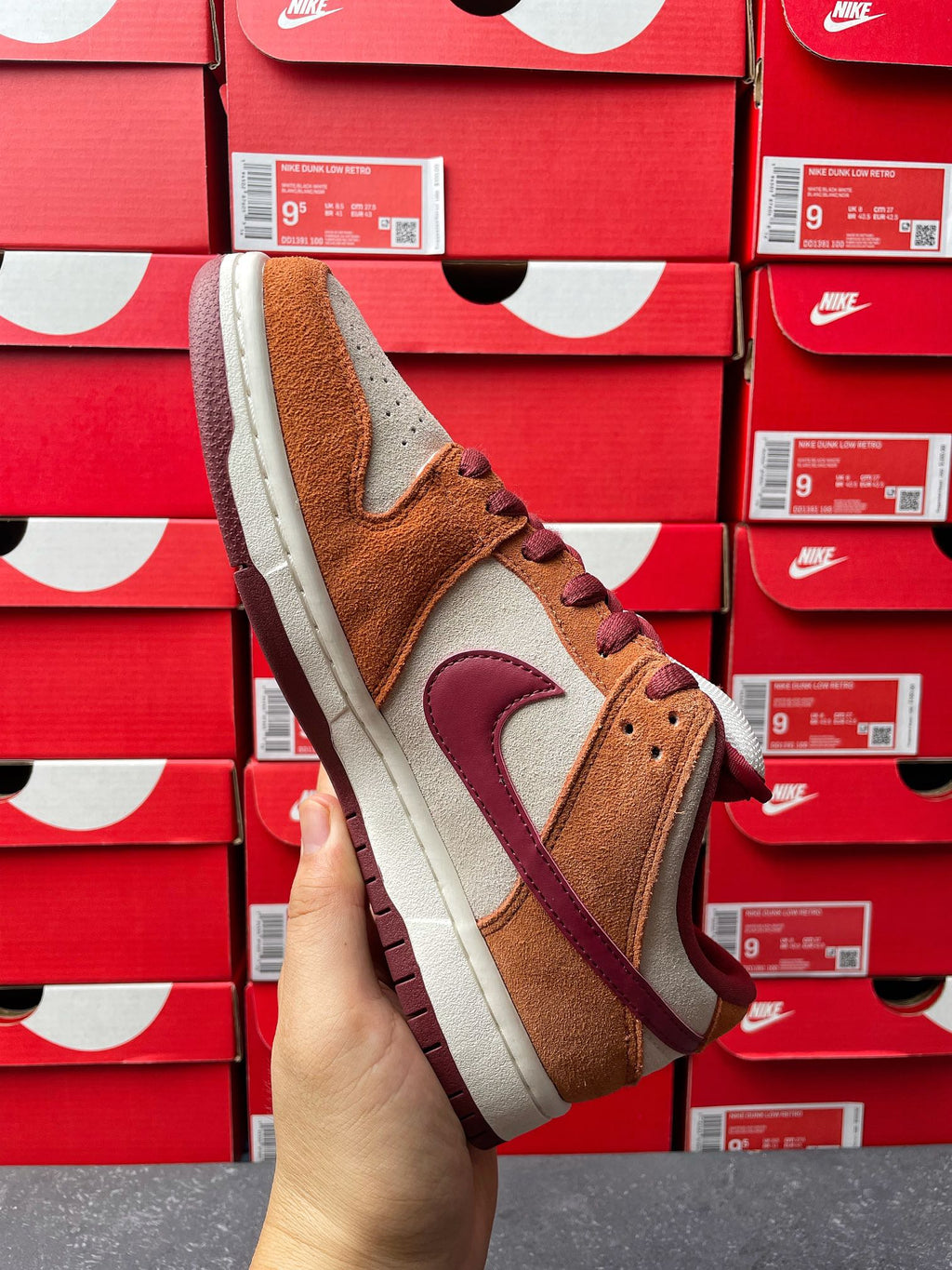 Nike Dunk Low sneaker front-side view with tan suede upper, burgundy swoosh, cream sole