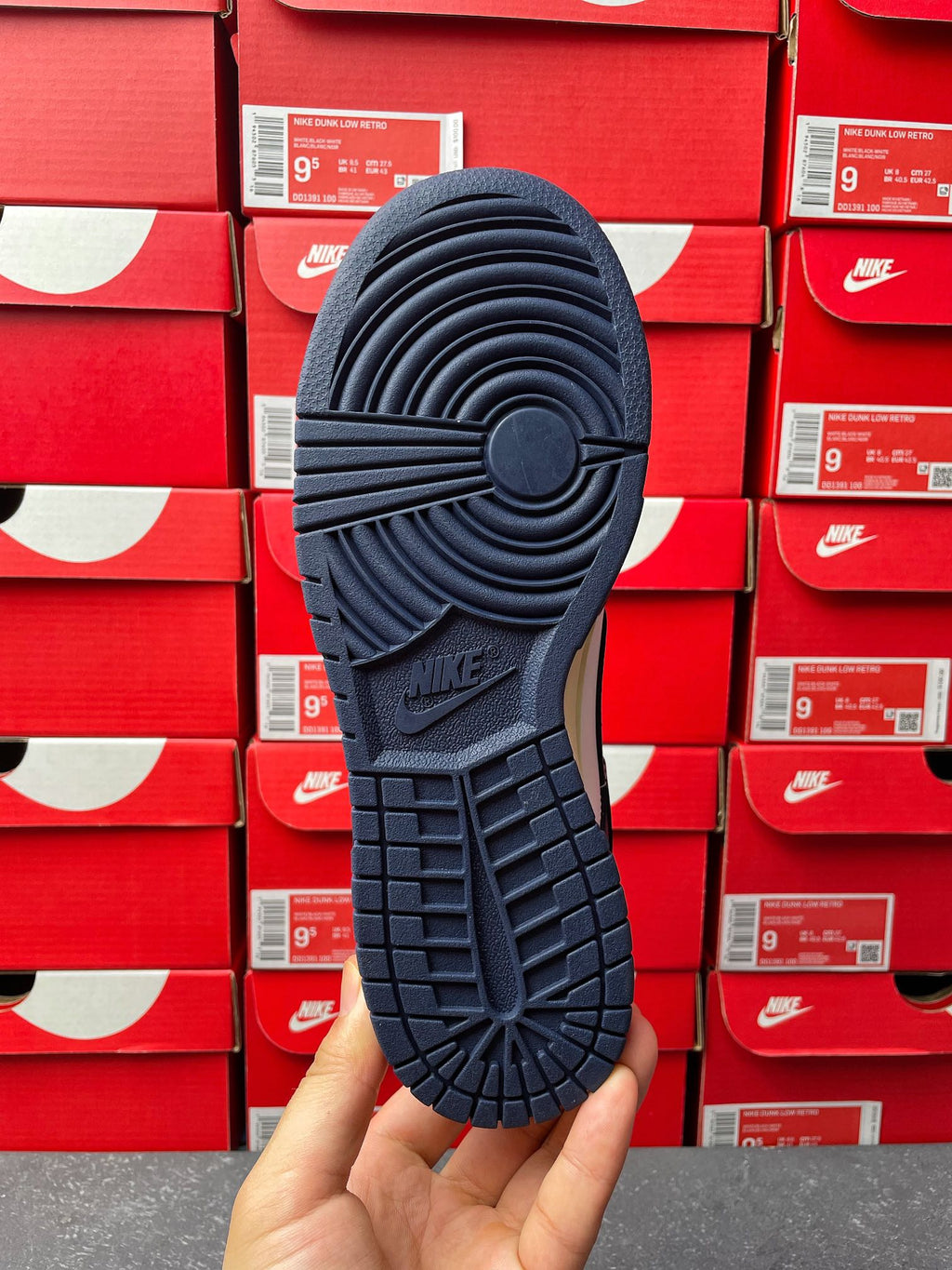 Navy low-top sneaker outsole view with tread pattern and Nike mark