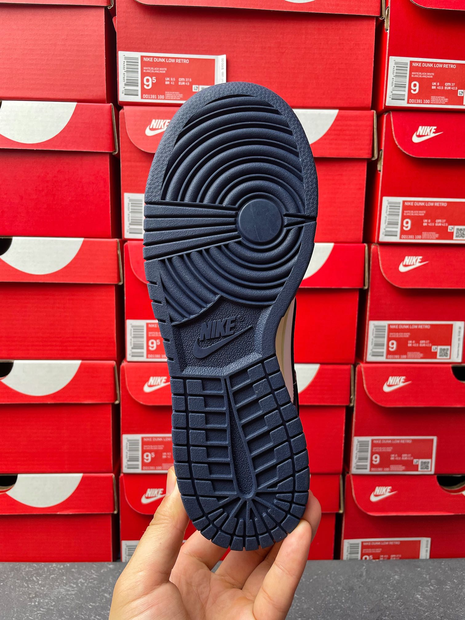Navy low-top sneaker outsole view with tread pattern and Nike mark