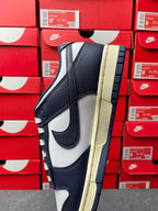 Midnight navy and white low-top sneakers with lace-up front, cream sole edge view