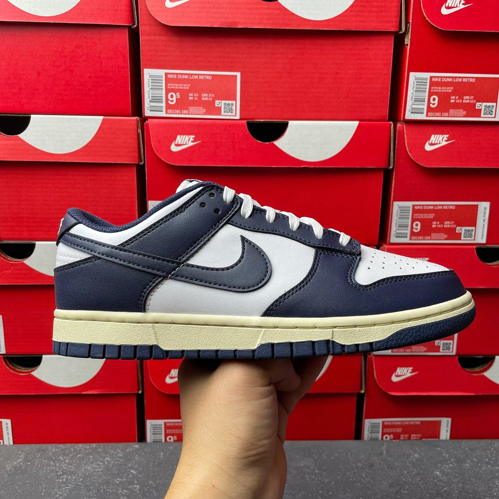 Midnight navy and white low-top sneakers with Nike swoosh and cream rubber sole