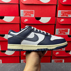 Midnight navy and white low-top sneakers with Nike swoosh and cream rubber sole