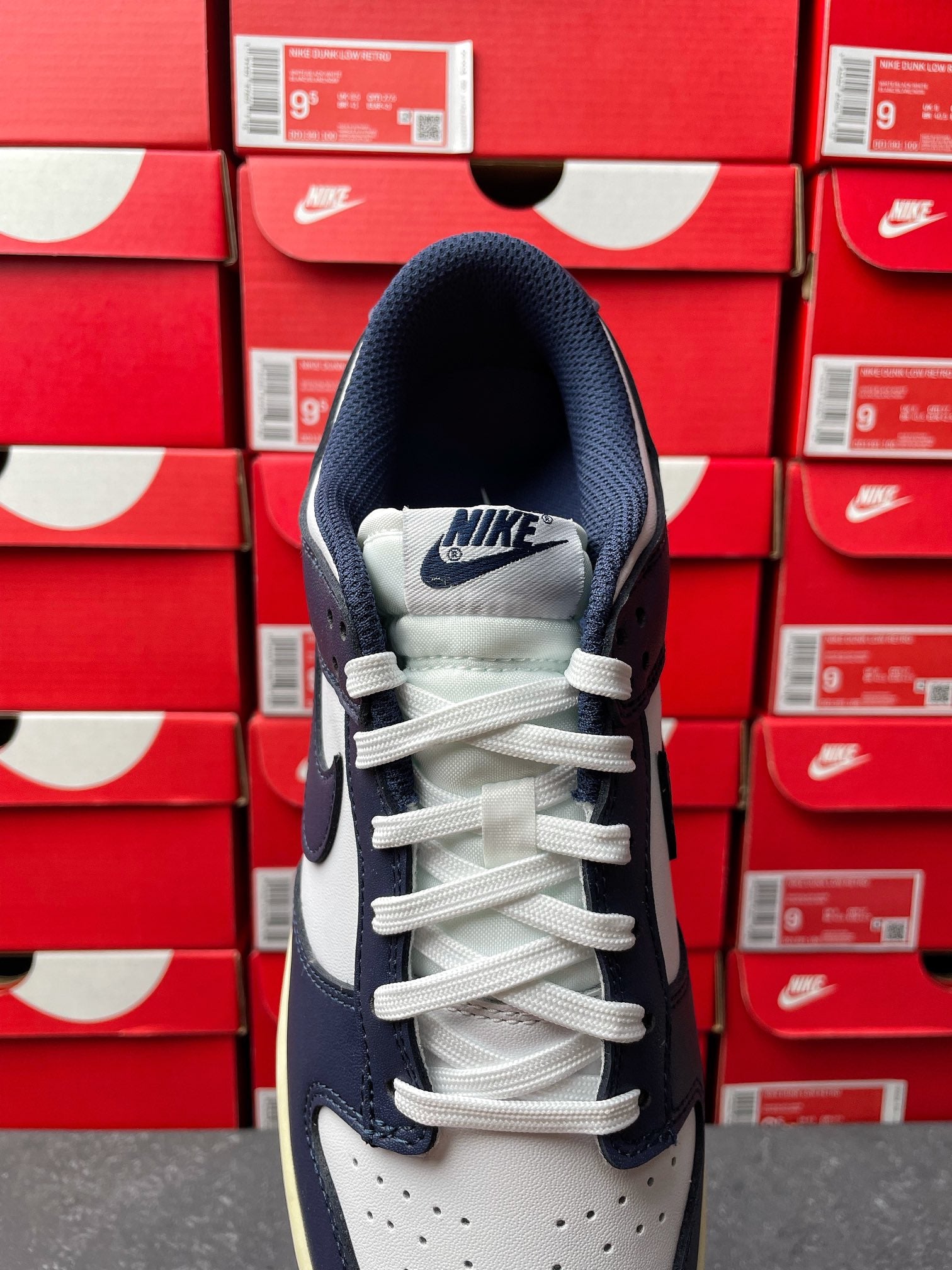 Midnight navy and white low-top sneakers with white laces and Nike logo on tongue
