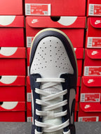 White perforated toe box on navy and white low-top sneakers with white laces