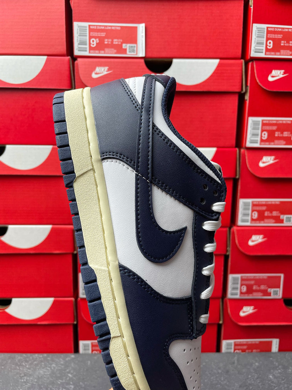 Midnight navy and white low-top sneakers with cream outsole, front side angle