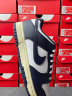 Midnight navy and white low-top sneakers with cream outsole, front side angle