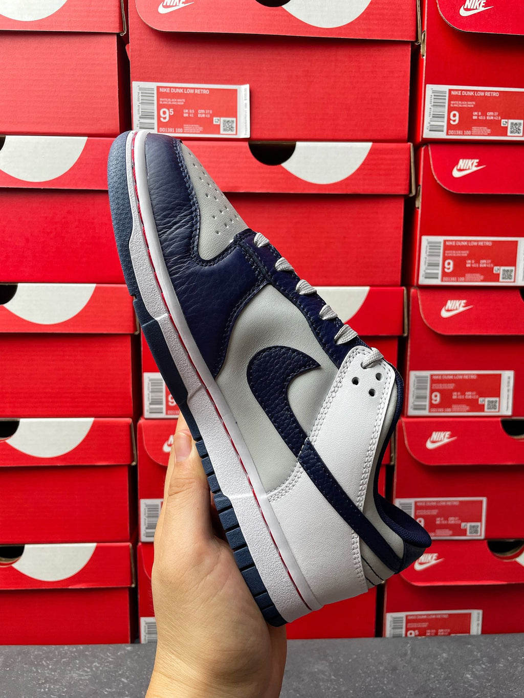 Low-top sneakers, white and navy panels with blue laces, perforated toe and Swoosh.