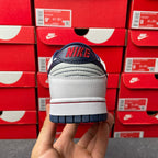 Low-top sneakers, white heel with navy back logo, cushioned collar, dark blue outsole.